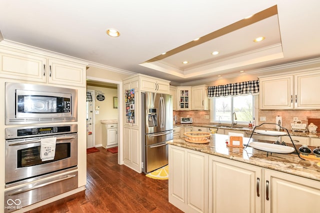 1153 Diablo Rd, Greenwood, IN 46143 - kitchen with a tray ceiling, cream cabinetry, a warming drawer, appliances with stainless steel finishes, and a sink