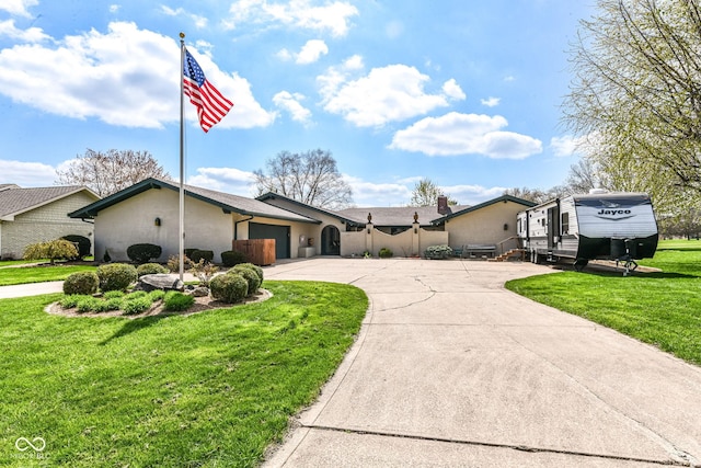 1153 Diablo Rd, Greenwood, IN 46143 - mid-century modern home featuring an attached garage, curved driveway, a front yard, and stucco siding