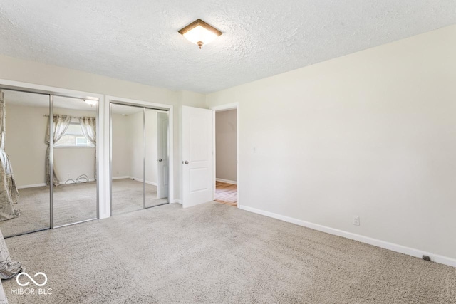 10129 Guilford Ave, Carmel, IN 46280 - unfurnished bedroom featuring carpet flooring, a textured ceiling, two closets, and baseboards