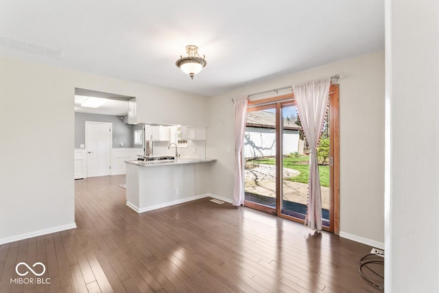 10129 Guilford Ave, Carmel, IN 46280 - kitchen with light countertops, dark wood-style flooring, baseboards, visible vents, and a peninsula