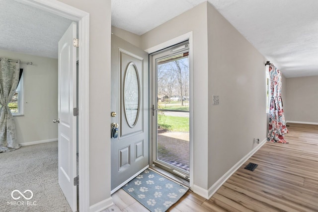 10129 Guilford Ave, Carmel, IN 46280 - foyer with baseboards, wood finished floors, and a textured ceiling