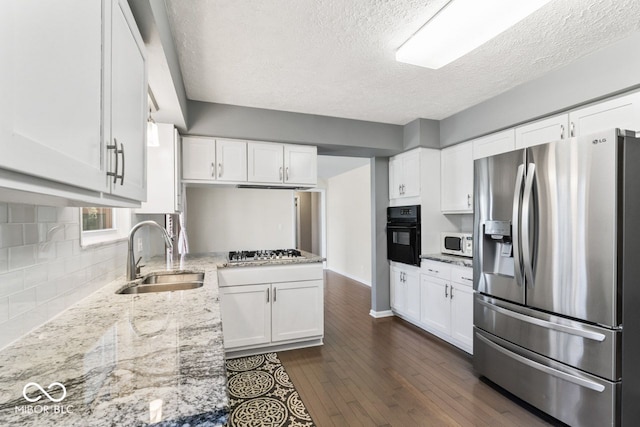 10129 Guilford Ave, Carmel, IN 46280 - kitchen with white cabinets, a sink, appliances with stainless steel finishes, dark wood-style flooring, and light stone countertops
