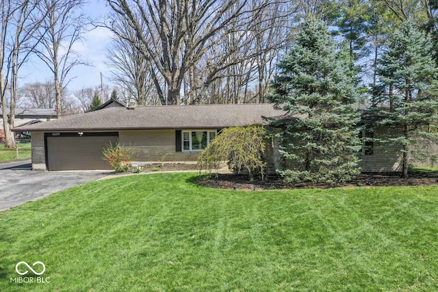 10129 Guilford Ave, Carmel, IN 46280 - single story home featuring brick siding, a front yard, an attached garage, and aphalt driveway