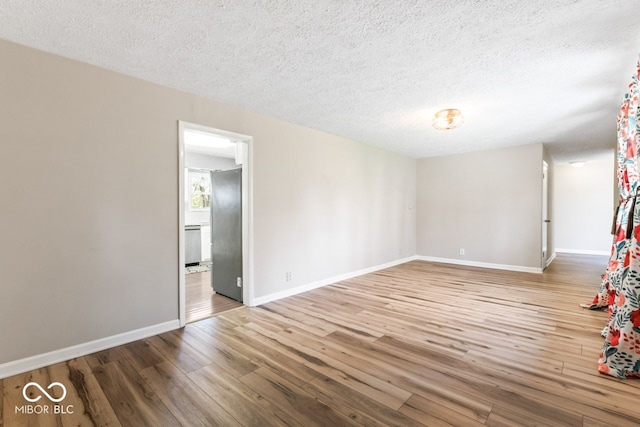 10129 Guilford Ave, Carmel, IN 46280 - empty room featuring a textured ceiling, wood finished floors, and baseboards