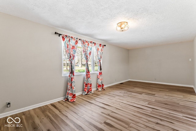 10129 Guilford Ave, Carmel, IN 46280 - unfurnished room featuring a textured ceiling, wood finished floors, and baseboards