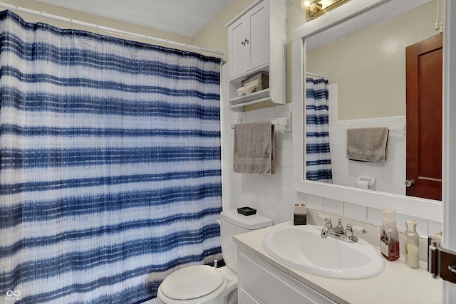 bathroom with tile walls, toilet, tasteful backsplash, vanity, and curtained shower