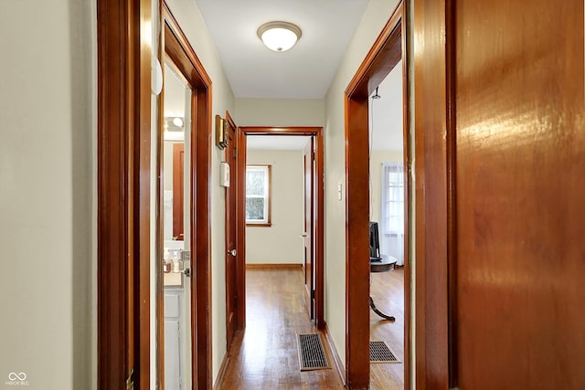 corridor with wood finished floors and baseboards