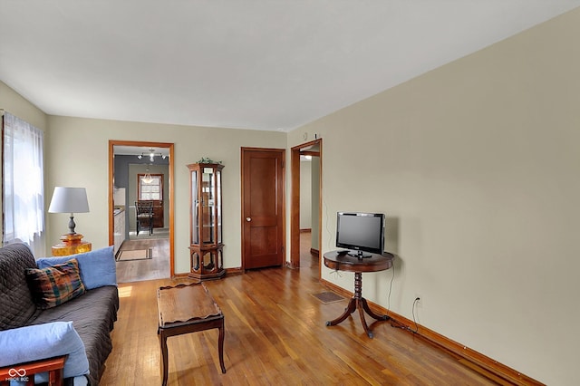 living room with wood finished floors, plenty of natural light, and baseboards