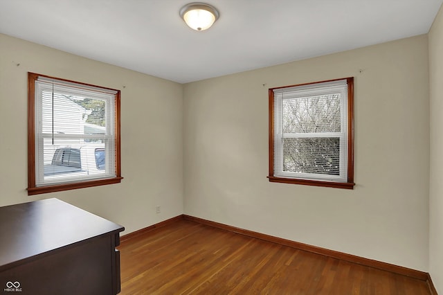unfurnished room with wood finished floors and baseboards