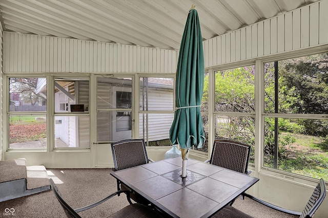 sunroom / solarium featuring outdoor dining area and healthy amount of natural light