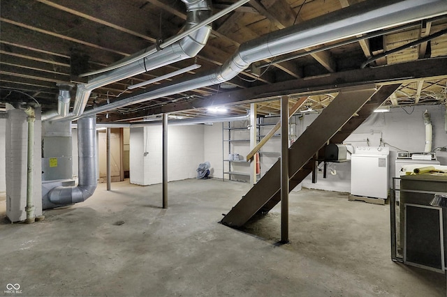 unfinished basement featuring independent washer and dryer, heating unit, and stairway