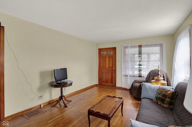 living room with wood finished floors, plenty of natural light, and baseboards