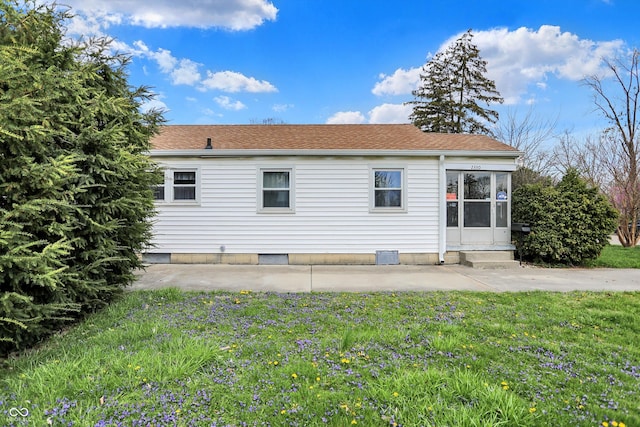 rear view of property featuring a yard, entry steps, a patio area, and roof with shingles