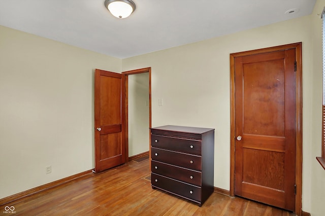 bedroom with light wood-style flooring and baseboards