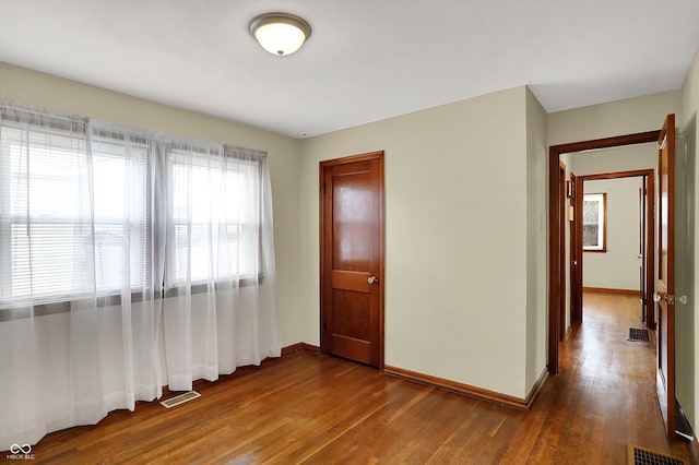 empty room featuring wood-type flooring and baseboards