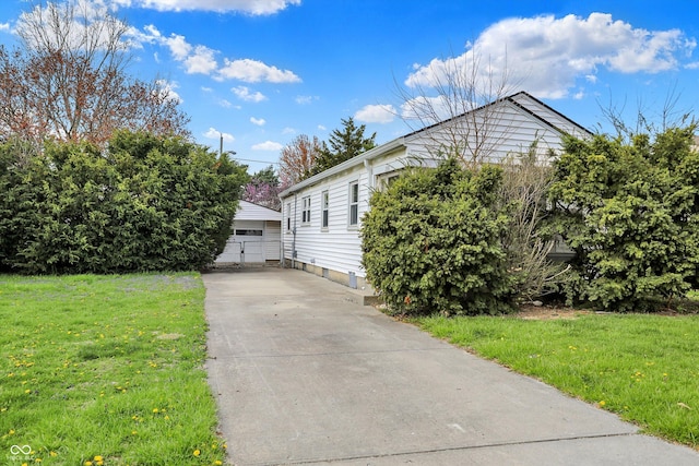 view of front of house with a front yard and a detached garage