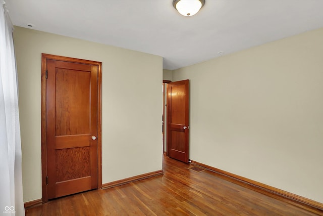 unfurnished bedroom with wood finished floors and baseboards