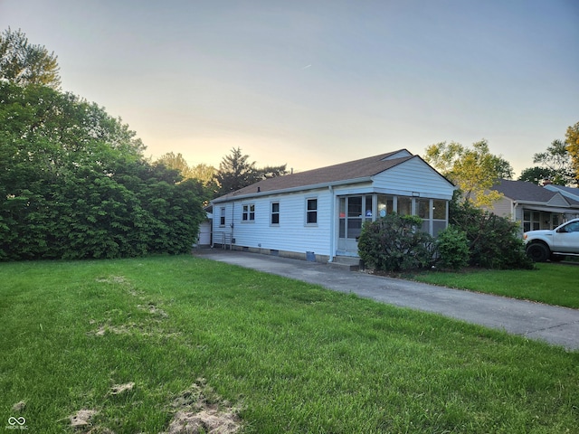 ranch-style home with a yard, a shingled roof, and entry steps