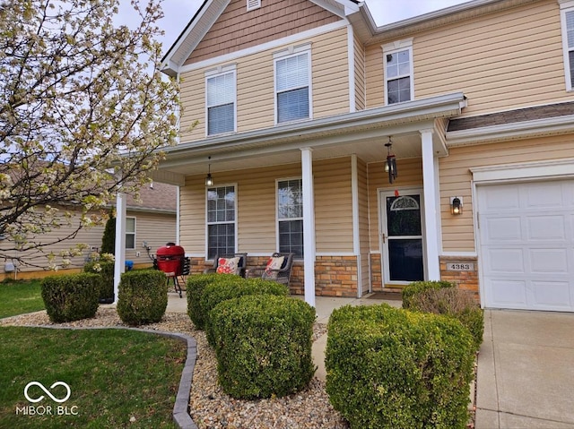 4383 Round Lake Bnd, Indianapolis, IN 46234 - view of front facade with covered porch, stone siding, and a garage