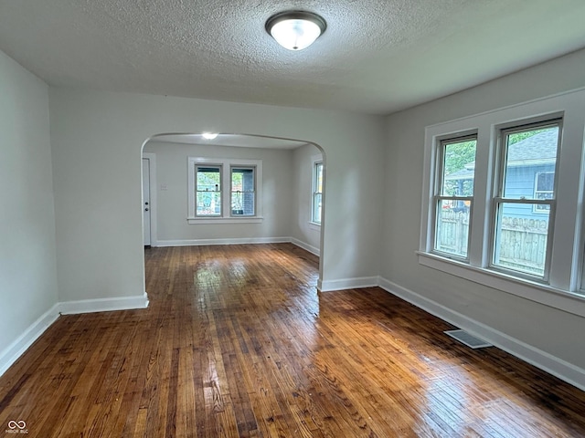 1032 Groff Ave, Indianapolis, IN 46222 - unfurnished room with arched walkways, a textured ceiling, dark wood finished floors, and baseboards