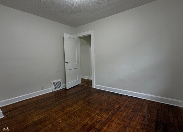 1032 Groff Ave, Indianapolis, IN 46222 - empty room with dark wood finished floors, baseboards, and a textured ceiling