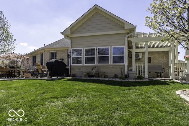 back of property with a yard, brick siding, and a patio area