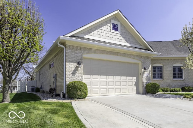 view of front facade with concrete driveway, cooling unit, an attached garage, a front yard, and brick siding