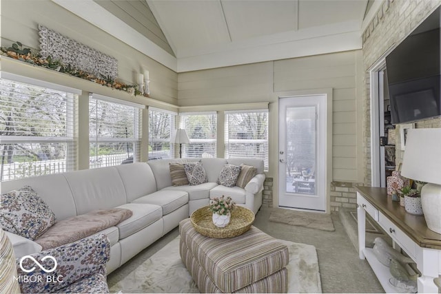 sunroom with high vaulted ceiling and carpet