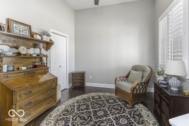 sitting room with baseboards and dark wood finished floors