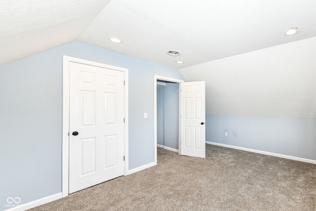 additional living space with carpet, visible vents, baseboards, and vaulted ceiling
