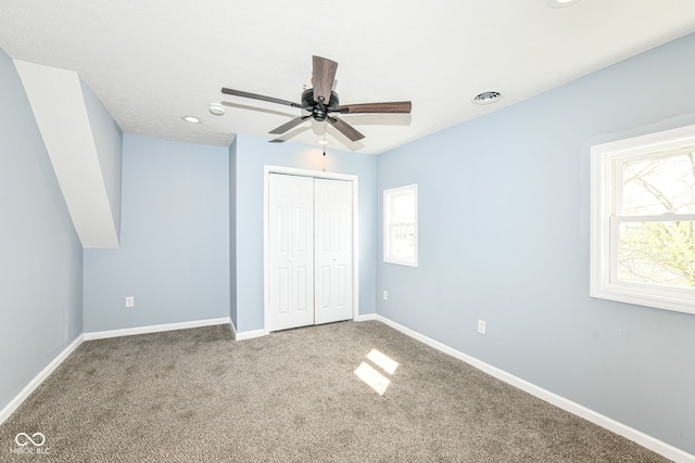 unfurnished bedroom with multiple windows, baseboards, visible vents, and carpet floors