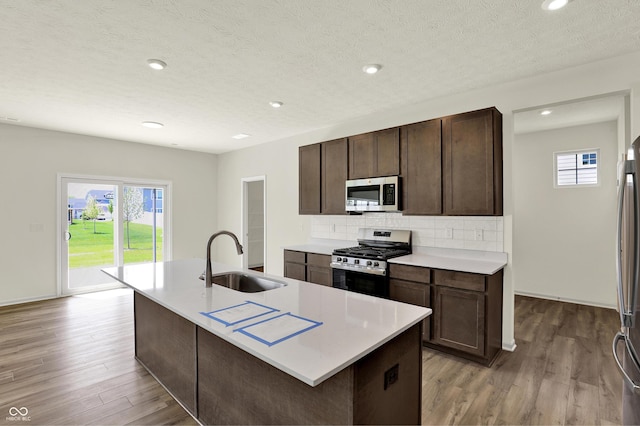 3727 Thomas Jefferson Ct, Westfield, IN 46074 - kitchen featuring stainless steel appliances, a sink, light wood-style floors, decorative backsplash, and recessed lighting