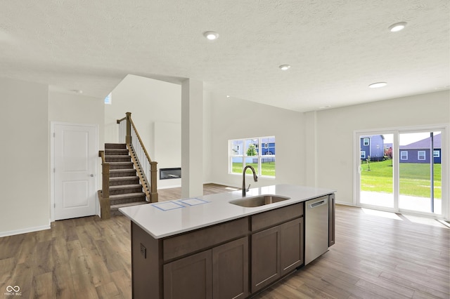 3727 Thomas Jefferson Ct, Westfield, IN 46074 - kitchen with stainless steel dishwasher, a sink, light wood-style floors, light countertops, and a textured ceiling