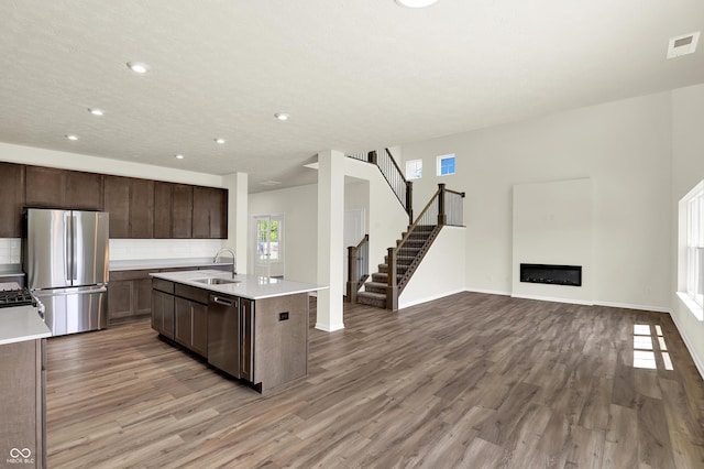 3727 Thomas Jefferson Ct, Westfield, IN 46074 - kitchen with appliances with stainless steel finishes, a sink, light countertops, wood finished floors, and tasteful backsplash