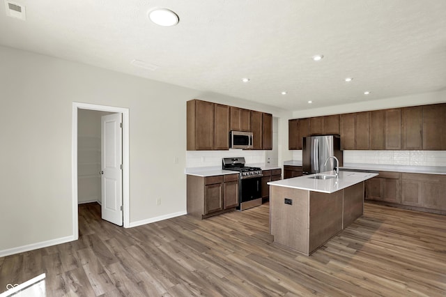 3727 Thomas Jefferson Ct, Westfield, IN 46074 - kitchen featuring stainless steel appliances, a sink, light wood-style floors, decorative backsplash, and baseboards