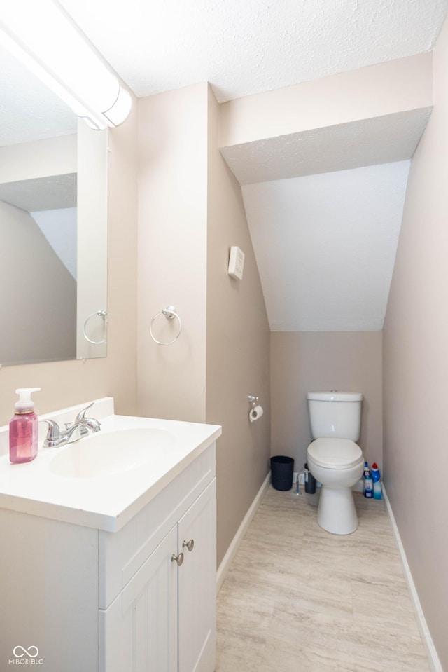 504 S Lebanon St, Lebanon, IN 46052 - half bathroom featuring vanity, baseboards, vaulted ceiling, toilet, and wood finished floors