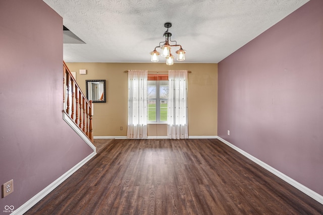 interior space featuring a chandelier, stairs, baseboards, and wood finished floors