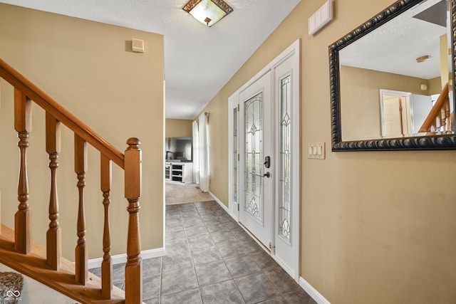 foyer featuring tile patterned flooring, stairway, and baseboards