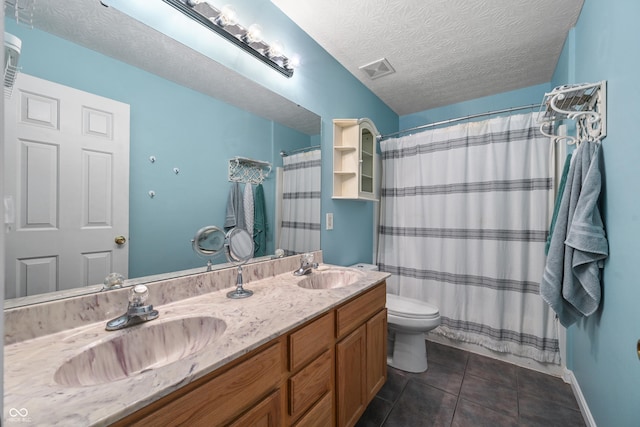 bathroom with a sink, visible vents, tile patterned floors, and a textured ceiling