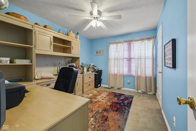 office area with light colored carpet, baseboards, a textured ceiling, and ceiling fan