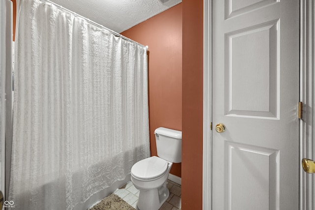 bathroom featuring toilet, shower / bath combination with curtain, tile patterned flooring, and baseboards