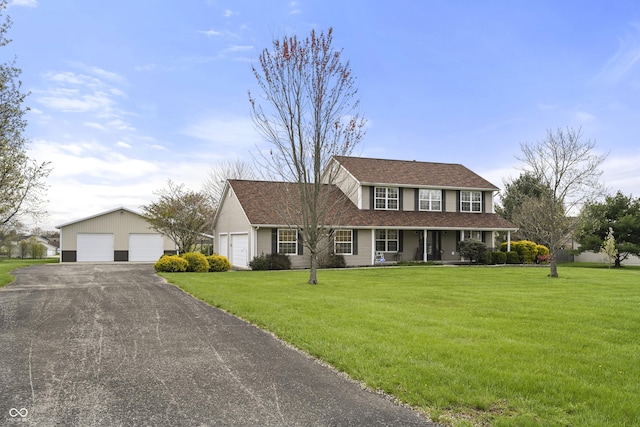 view of front of property with a front yard, a porch, an outdoor structure, and a garage