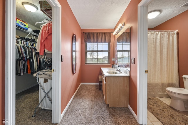 bathroom with vanity, baseboards, curtained shower, a textured ceiling, and toilet
