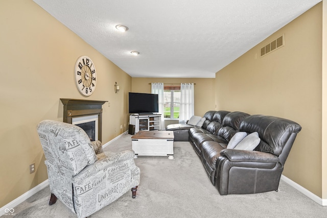 living area featuring carpet flooring, a glass covered fireplace, and visible vents
