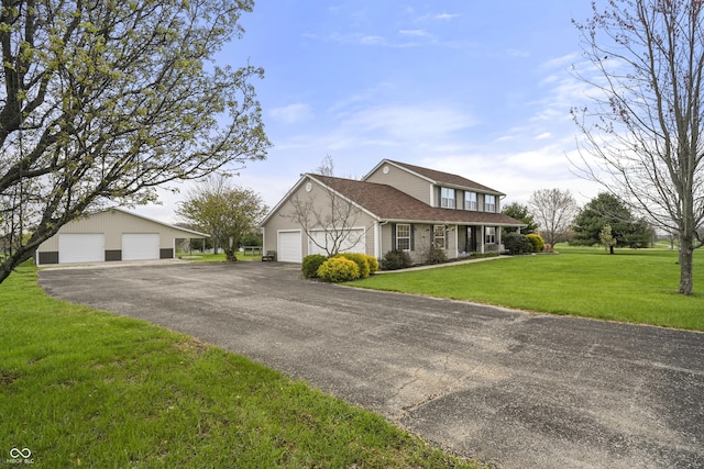 traditional home featuring a detached garage and a front lawn