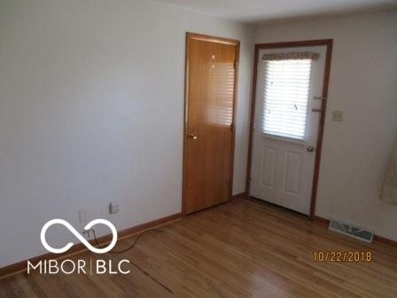 interior space with baseboards, a chandelier, wood finished floors, and visible vents