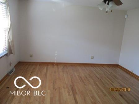 empty room featuring wood finished floors, baseboards, and ceiling fan