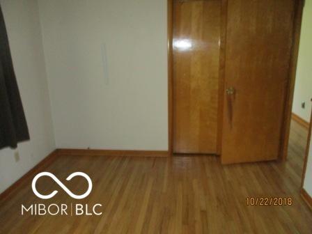 unfurnished bedroom with wood finished floors and baseboards