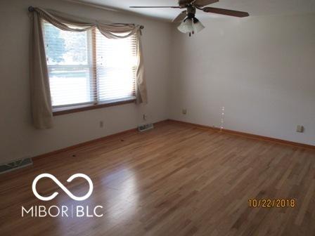 empty room featuring baseboards, wood finished floors, visible vents, and ceiling fan