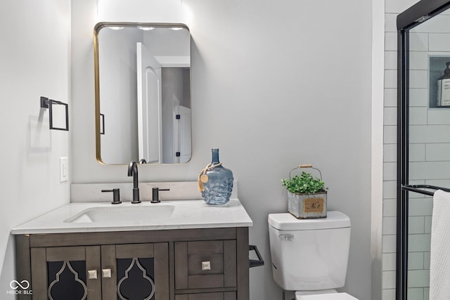 full bathroom featuring toilet, vanity, and a shower with door